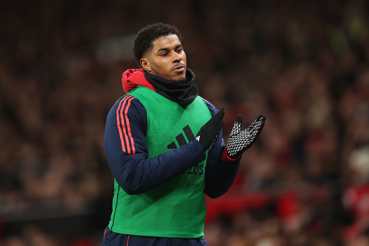 Marcus Rashford applauds the fans at Old Trafford as he warms up on the touchline.