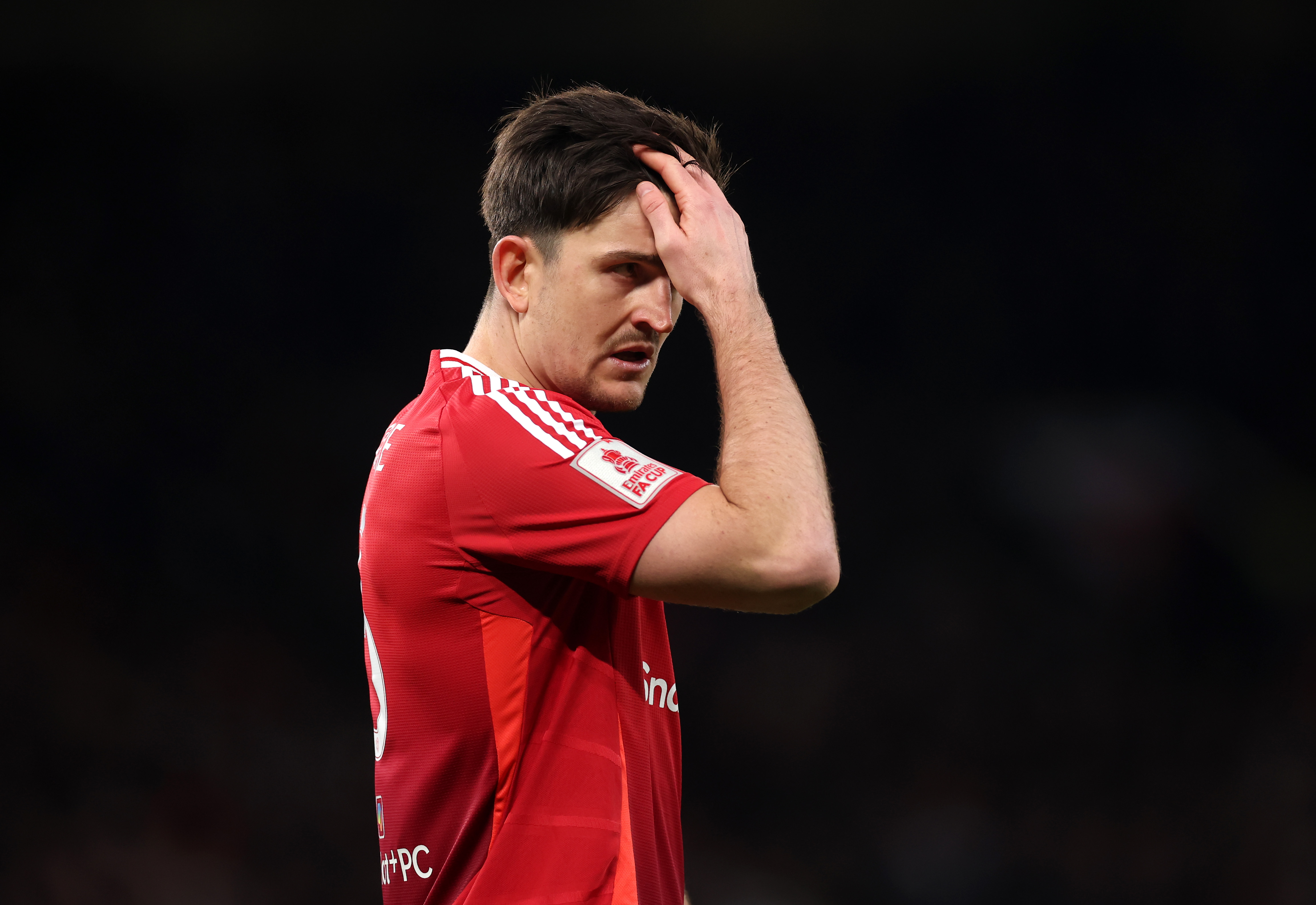 Harry Maguire fixes his hair while in action for Man United against Fulham.