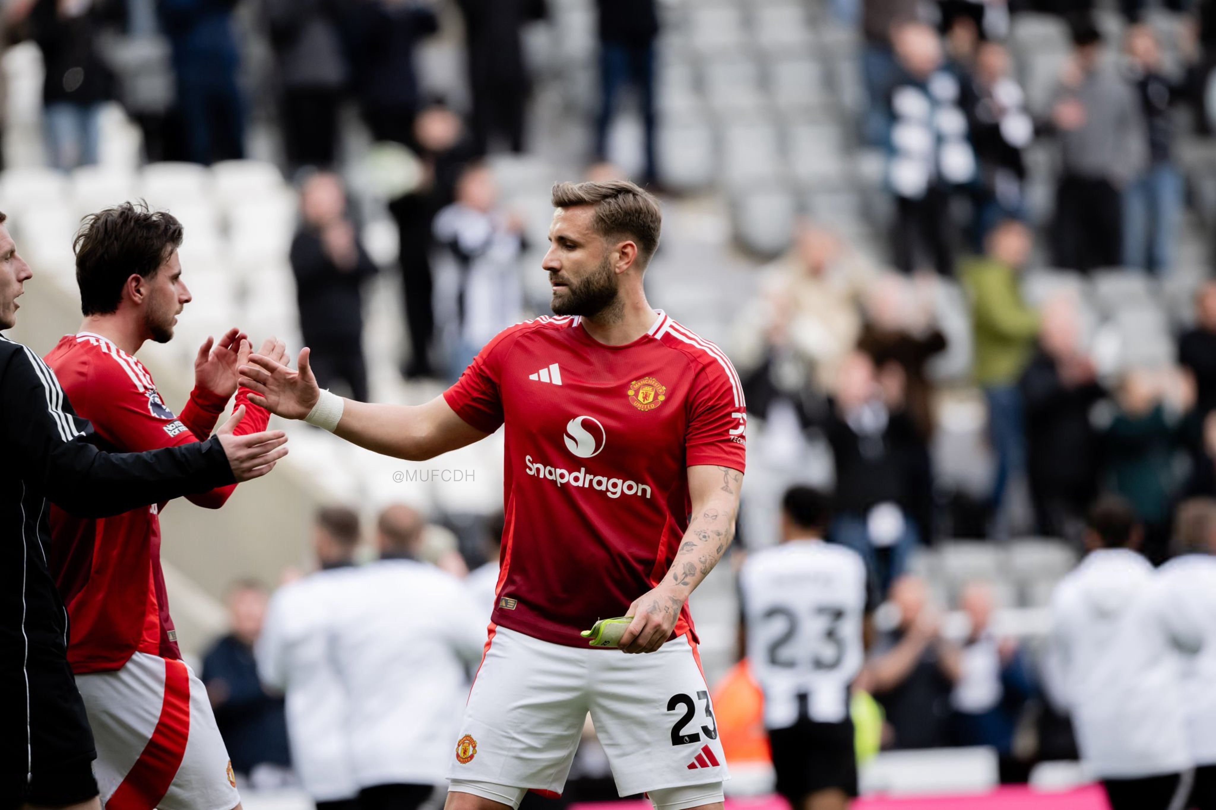 Luke Shaw shales the hands of a staff member alongside Mason Mount at full-time vs Newcastle.