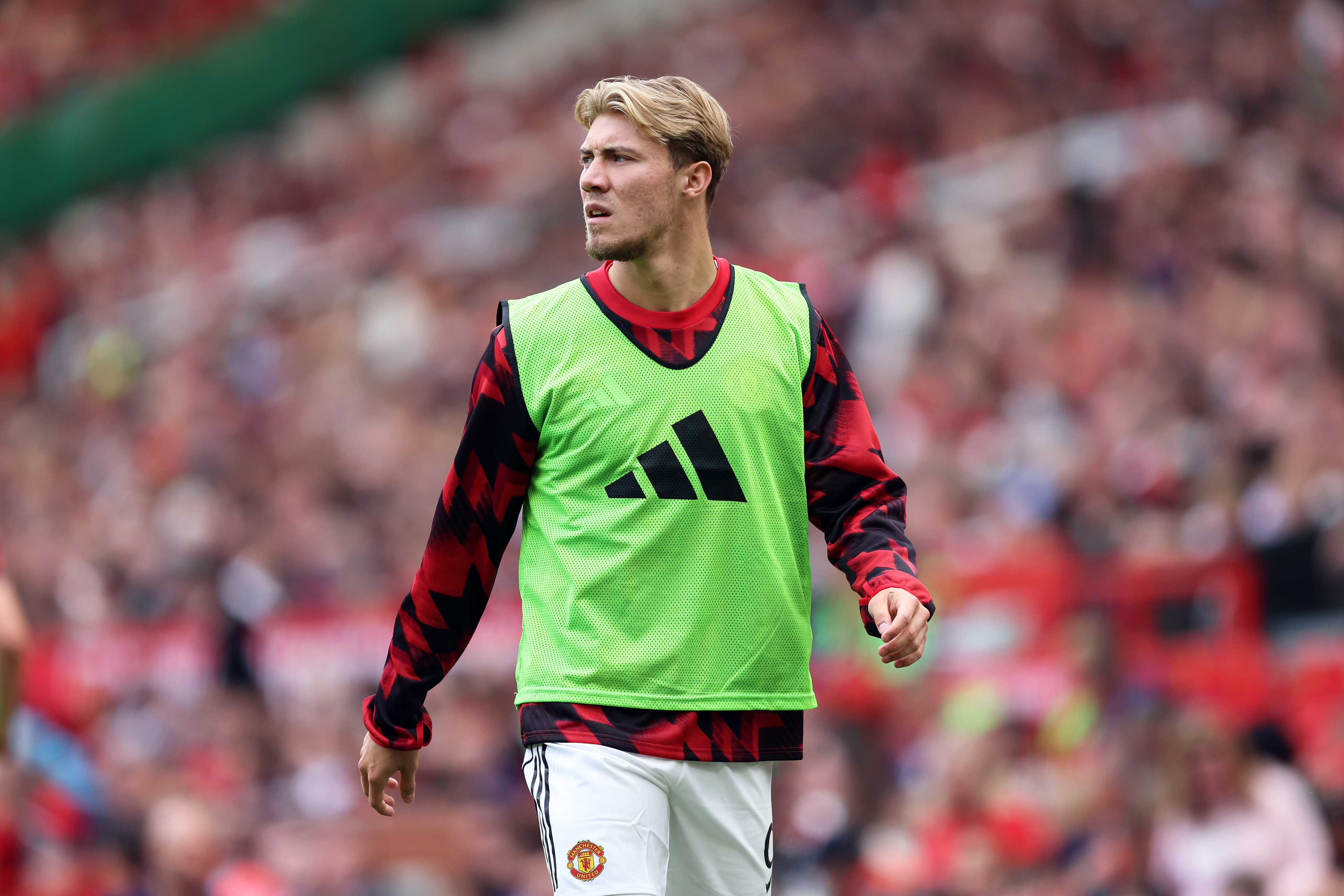 Rasmus Hojlund warms up on the touchline.