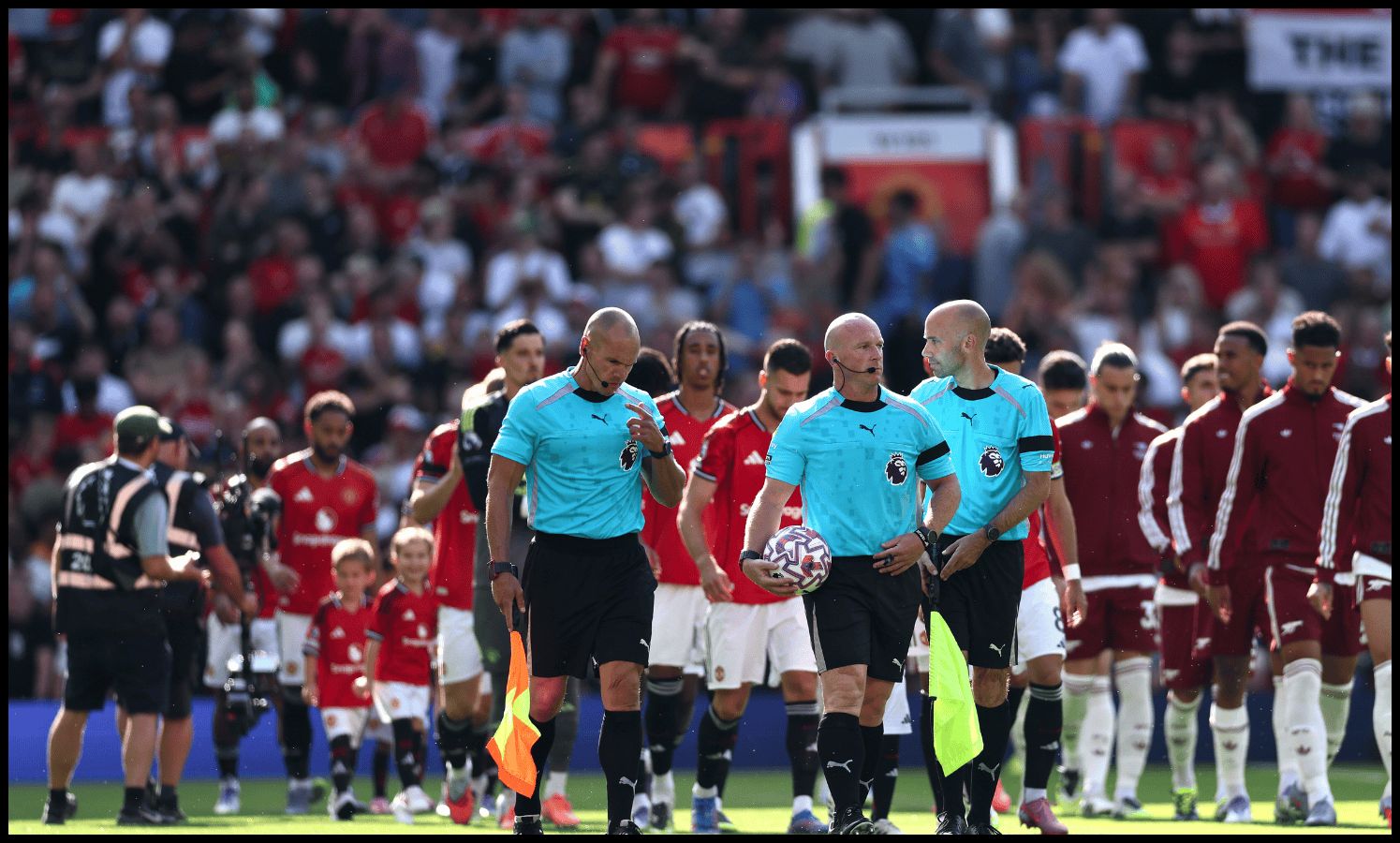 Referee Simon Hooper leads the players onto the field during the Premier League match between Manchester United and Arsenal at Old Trafford on August 17, 2025 in Manchester.