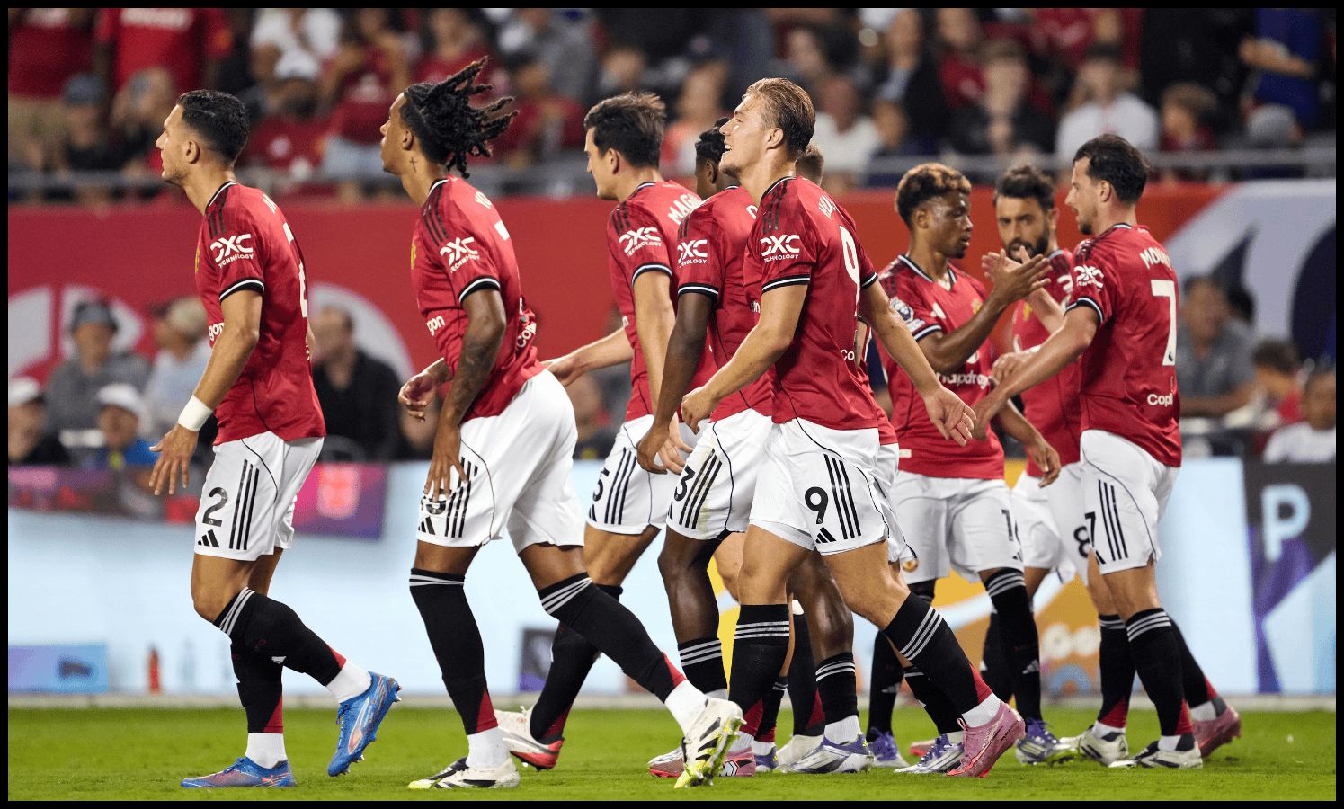 Rasmus Hojlund and the Man United squad celebrate after scoring a goal.