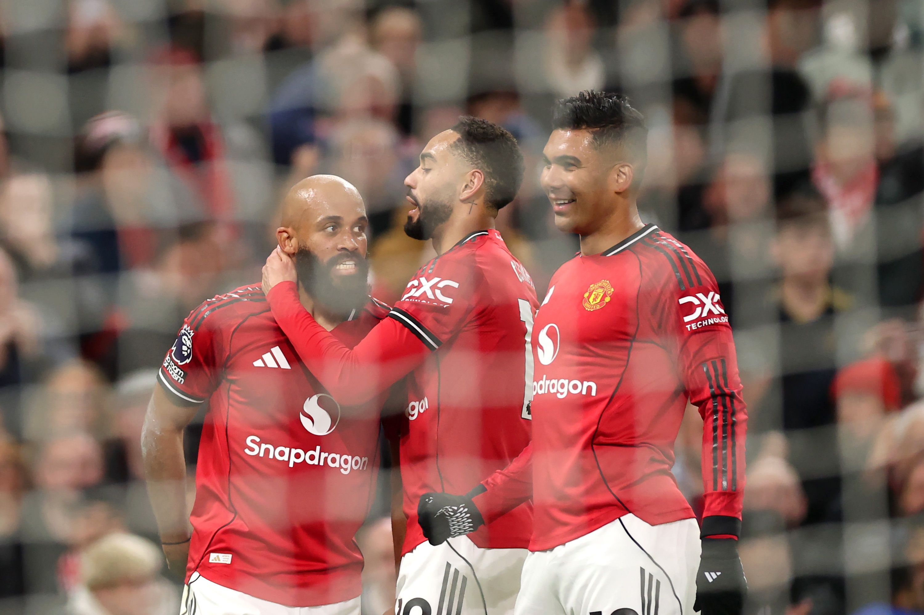 Matheus Cunha hugs Bryan Mbeumo during Man Utd game.