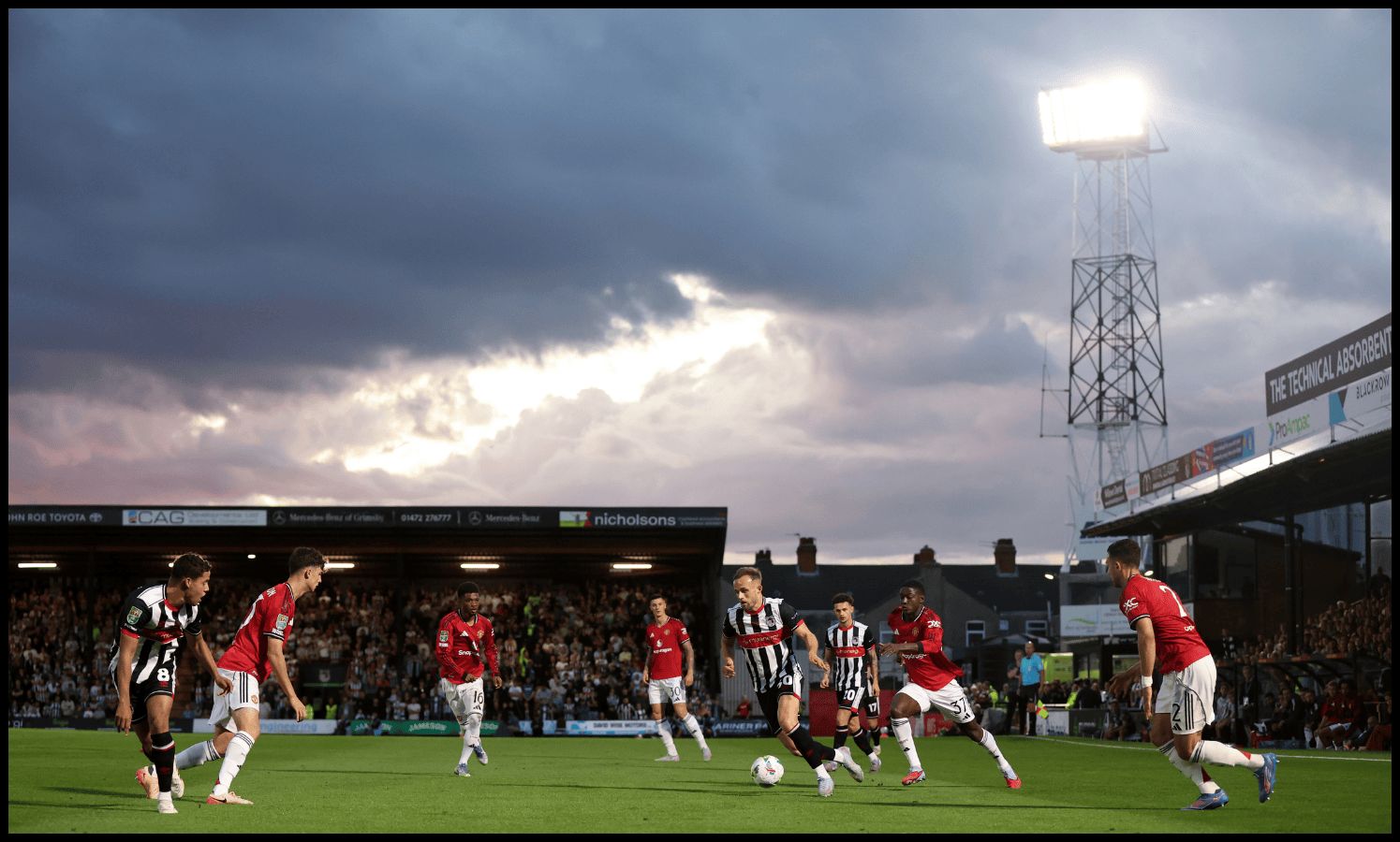 Man United and Grimsby players in action at Blundell Park.
