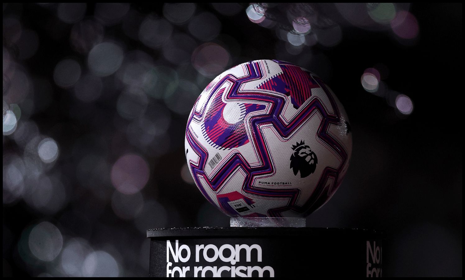 A Premier League match ball on top of a ‘No room for racism’ stand.