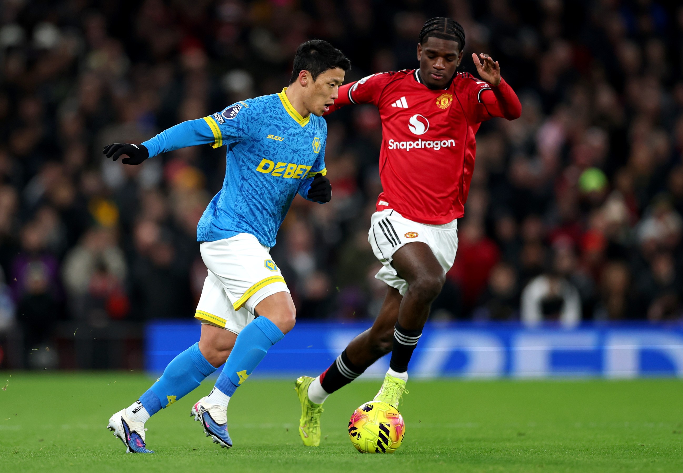 Hwang Hee-Chan of Wolverhampton Wanderers battles for possession with Ayden Heaven of Manchester United