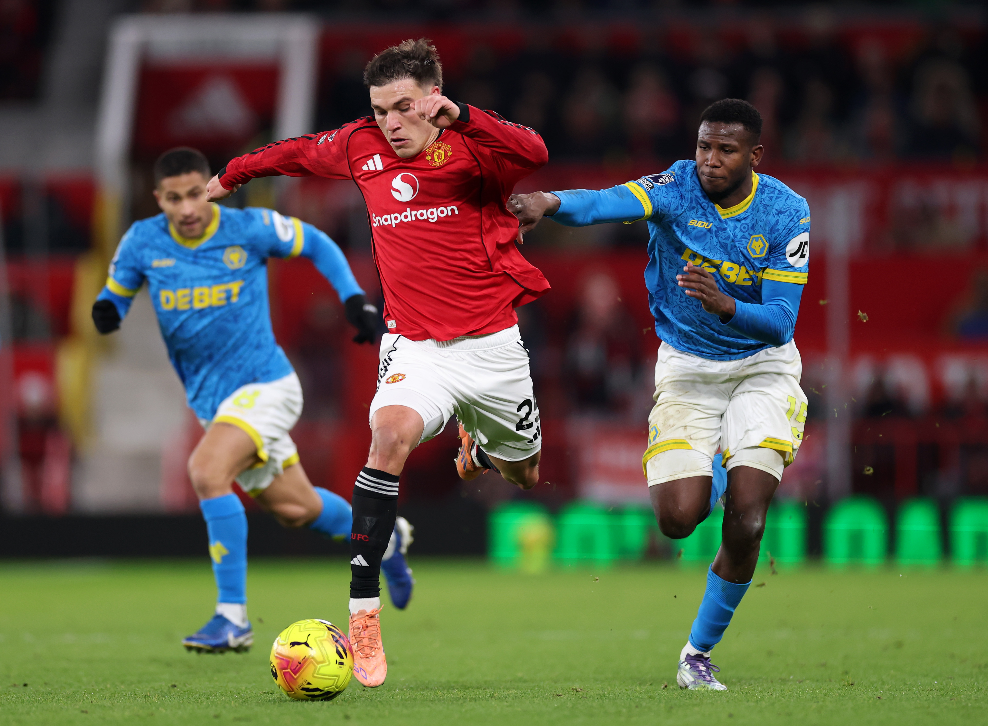 Manuel Ugarte runs while under pressure from Wolves players.