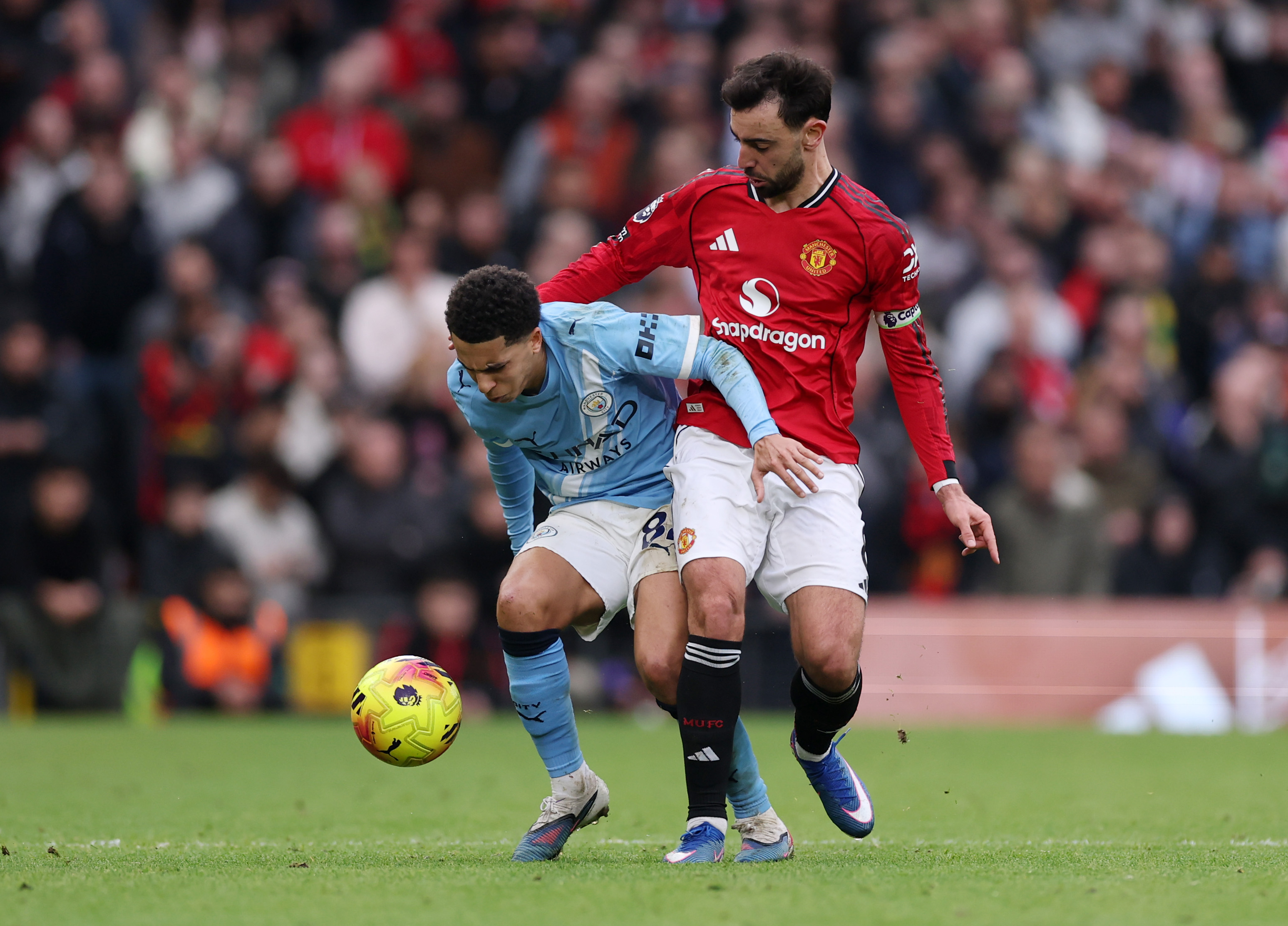 Bruno Fernandes challenges Rico Lewis of Manchester City.