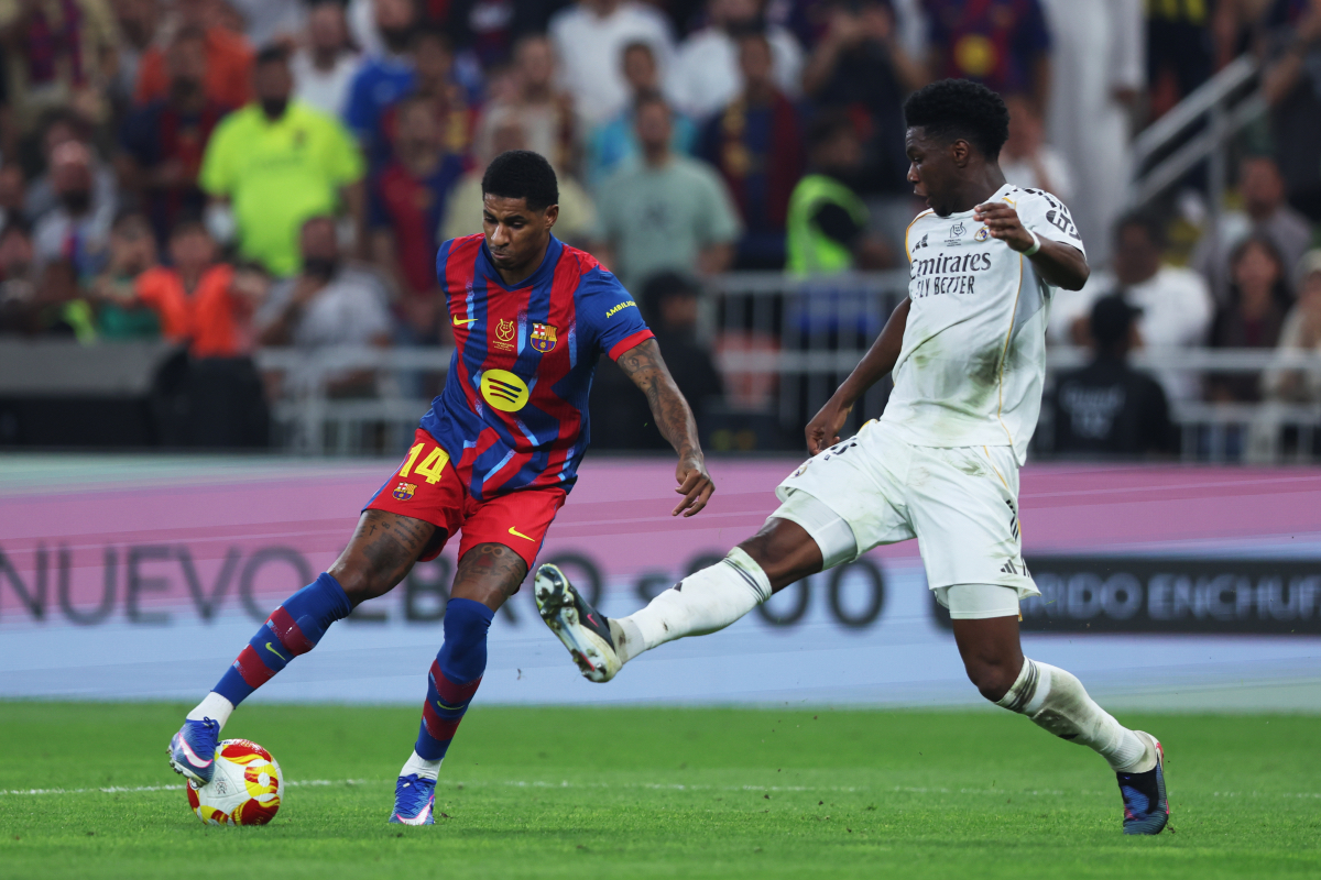 JEDDAH, SAUDI ARABIA - JANUARY 11: Marcus Rashford of FC Barcelona is challenged by Aurelien Tchouameni of Real Madrid during the Spanish Super Cup Final between FC Barcelona and Real Madrid at King Abdullah Sports City Hall Stadium on January 11, 2026 in Jeddah, Saudi Arabia. (Photo by Yasser Bakhsh/Getty Images)