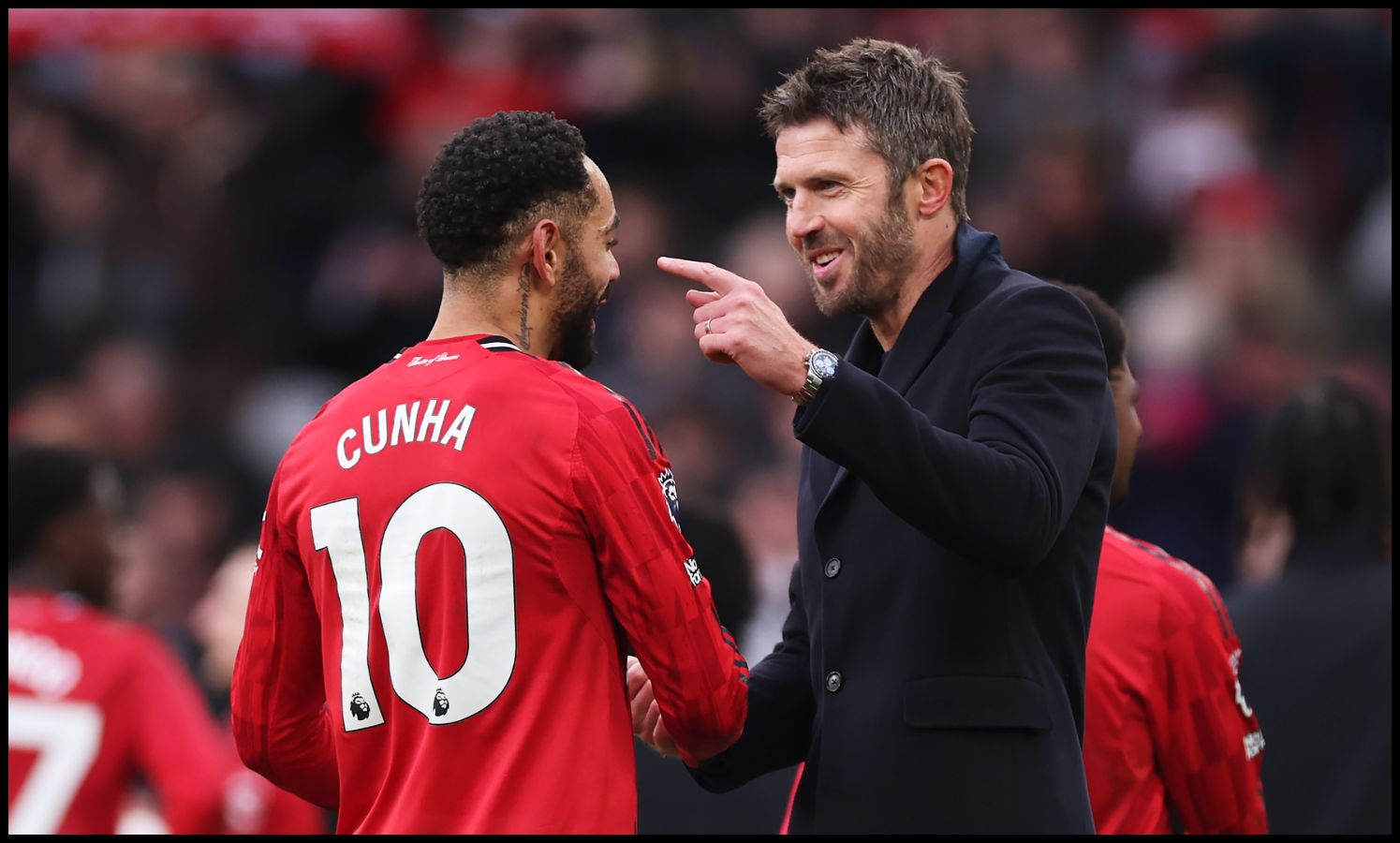 Michael Carrick shakes hands with Matheus Cunha and points.