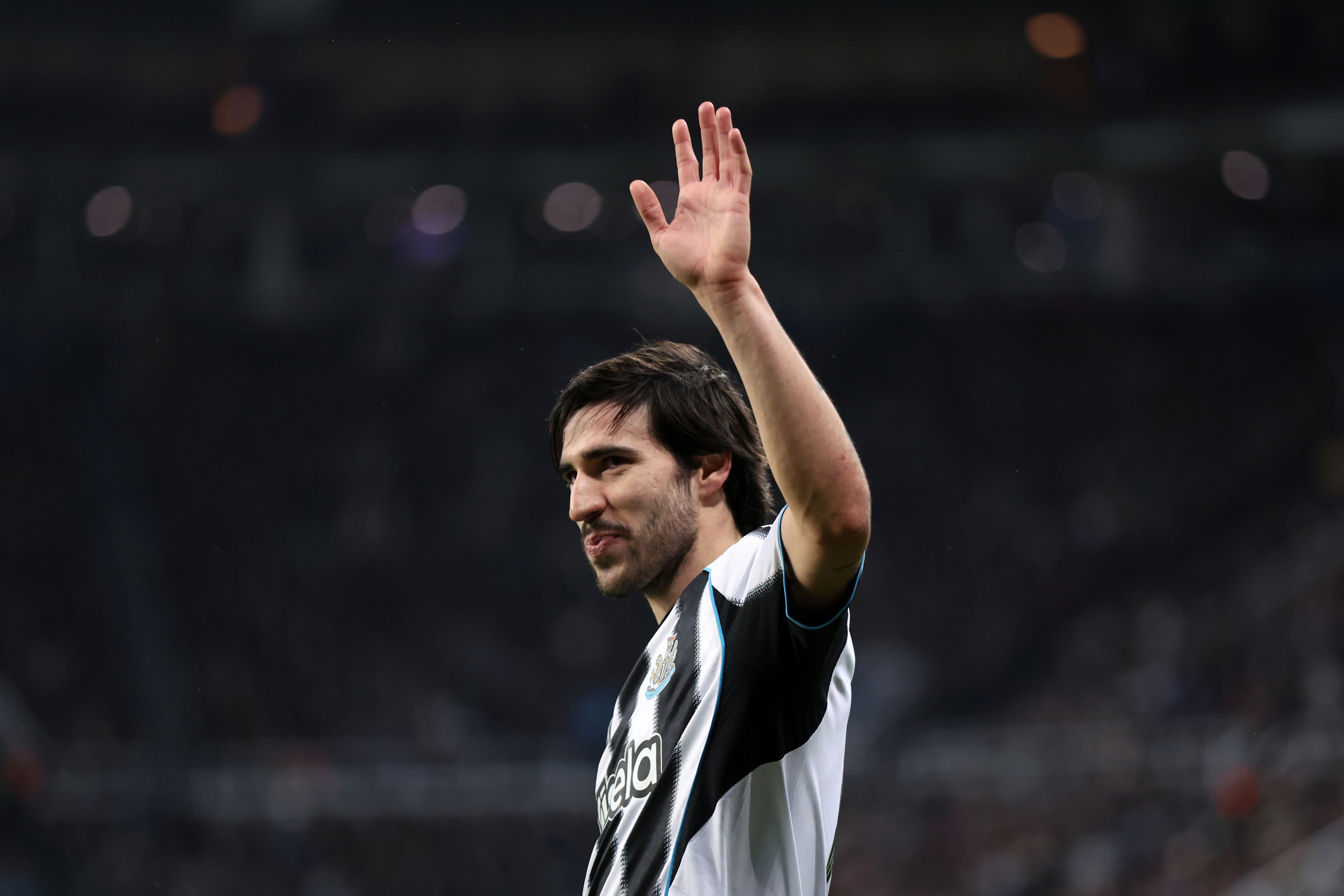 Sandro Tonali smiles and waves while in action for Newcastle vs PSV. 