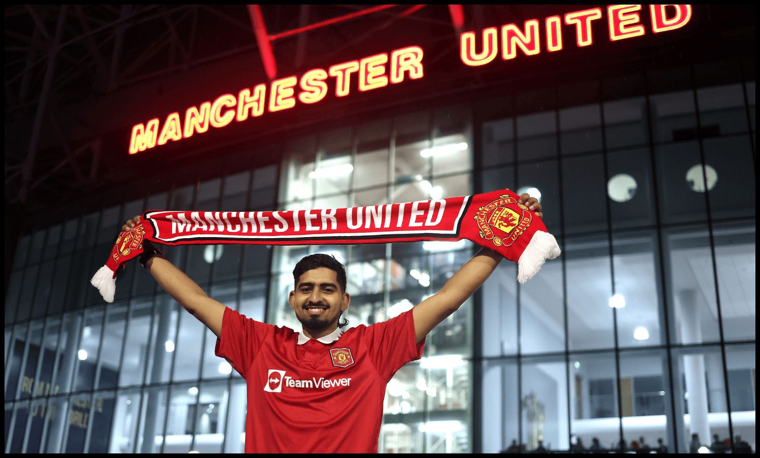 A Man United fan holds up a flag outside Old Trafford on matchday.