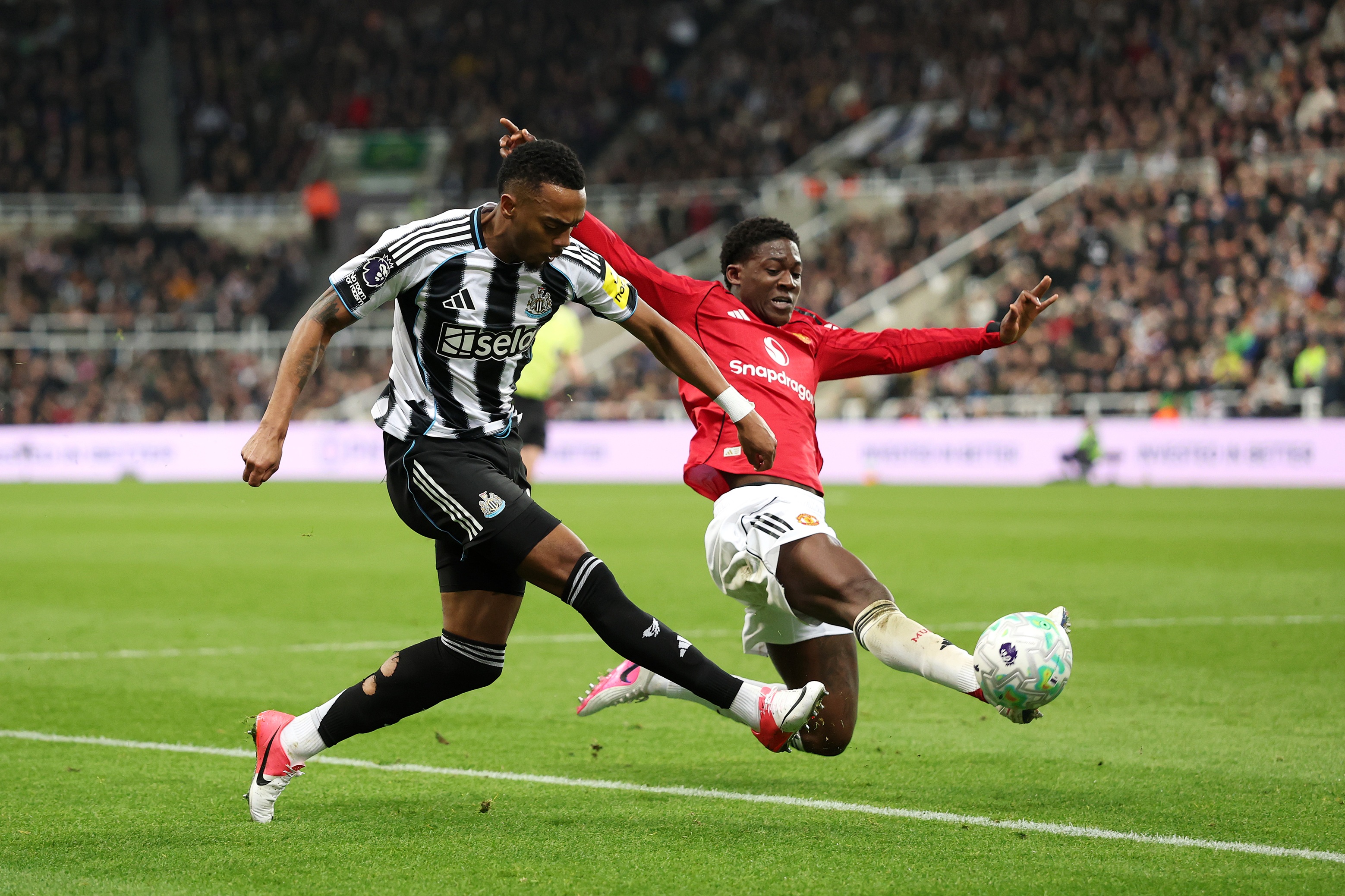 Kobbie Mainoo stretches out a leg to dispossess Joe Willock.