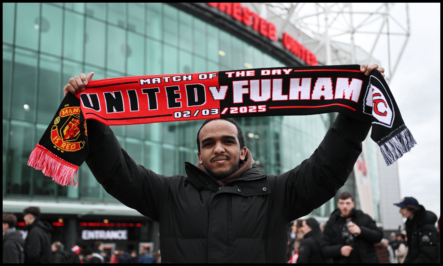MANCHESTER, ENGLAND - MARCH 02: A general view as a fan of Manchester United holds up a half and half match day scarf outside the stadium prior to the Emirates FA Cup Fifth Round match between Manchester United and Fulham at Old Trafford on March 02, 2025 in Manchester, England.
