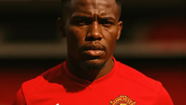 Manchester United player in red jersey at Old Trafford showing determination and commitment to the club