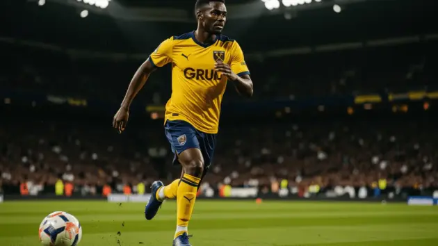 Crysencio Summerville sprinting with ball in West Ham kit under stadium lights
