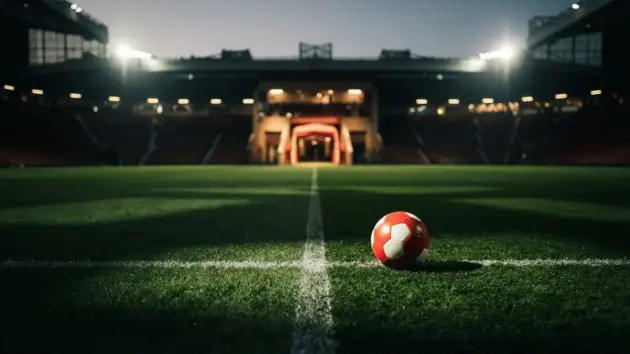 Manchester United football on Premier League pitch with stadium tunnel in background at dusk