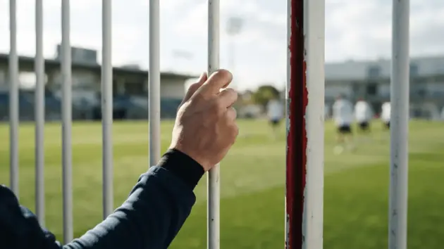 Real Madrid training ground fence with hand grip, symbolizing Camavinga's transfer decision standoff