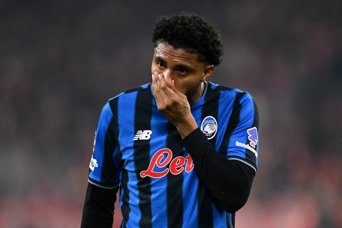 A football player in an Atalanta kit showing a pained expression on the pitch.
