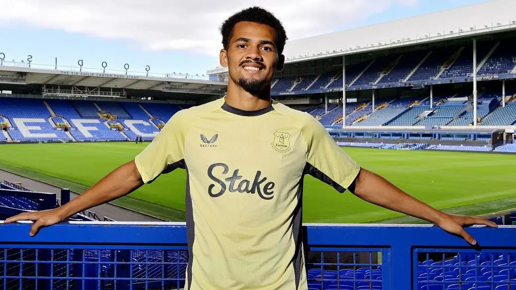 Iliman Ndiaye posing in a yellow Everton FC training kit at Goodison Park stadium
