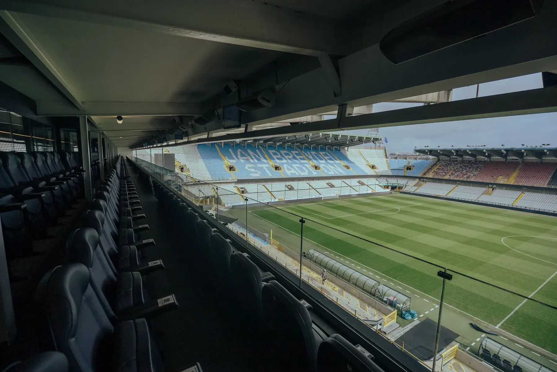 View from the VIP lounge of Jan Breydel Stadium showing the pitch and blue and white stands.