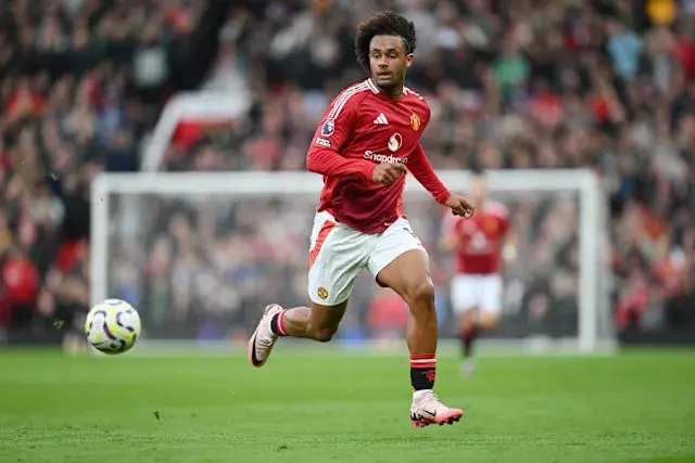 Joshua Zirkzee in a Manchester United red kit running with a soccer ball during a match