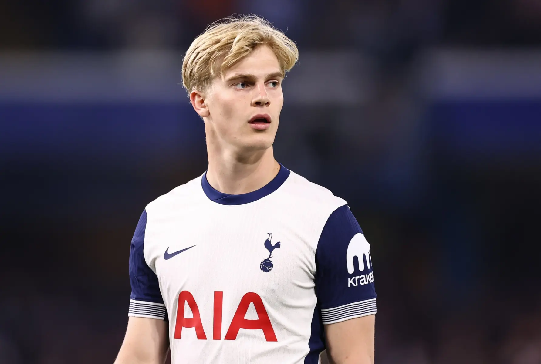 Lucas Bergvall in a white and navy Tottenham Hotspur home kit looking off-camera.