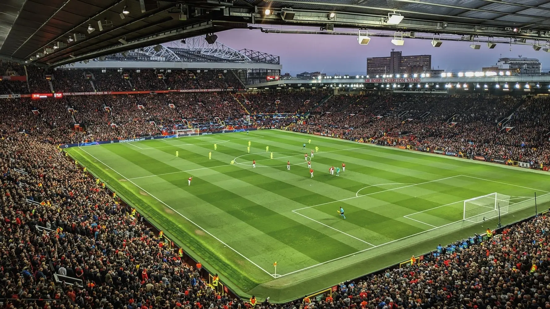 Wide shot of Old Trafford stadium during a Manchester United match with fans filling the stands