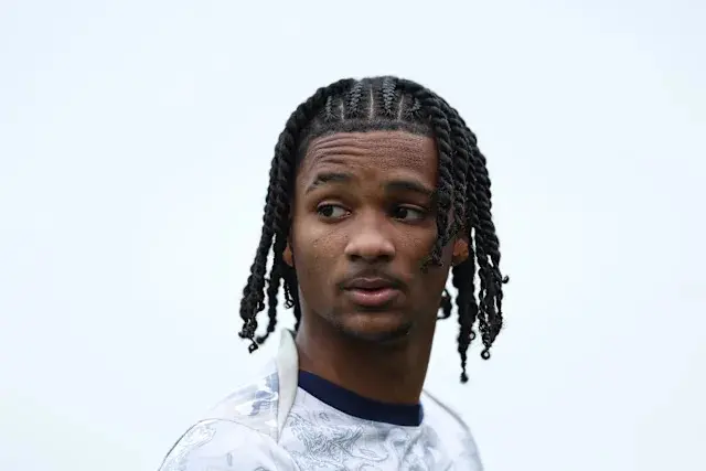 Tynan Thompson with braided hair, wearing a white sports jersey.