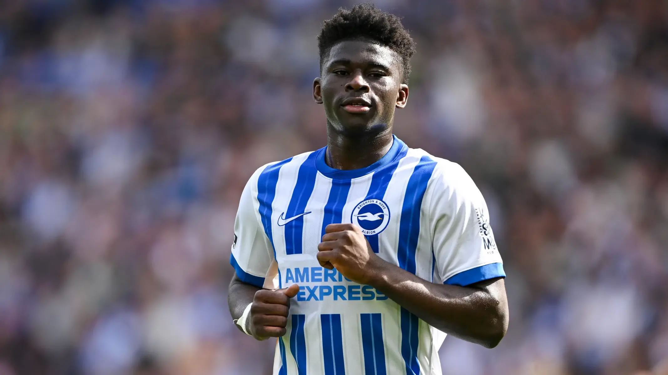 Carlos Baleba in a blue and white striped Brighton & Hove Albion kit during a match