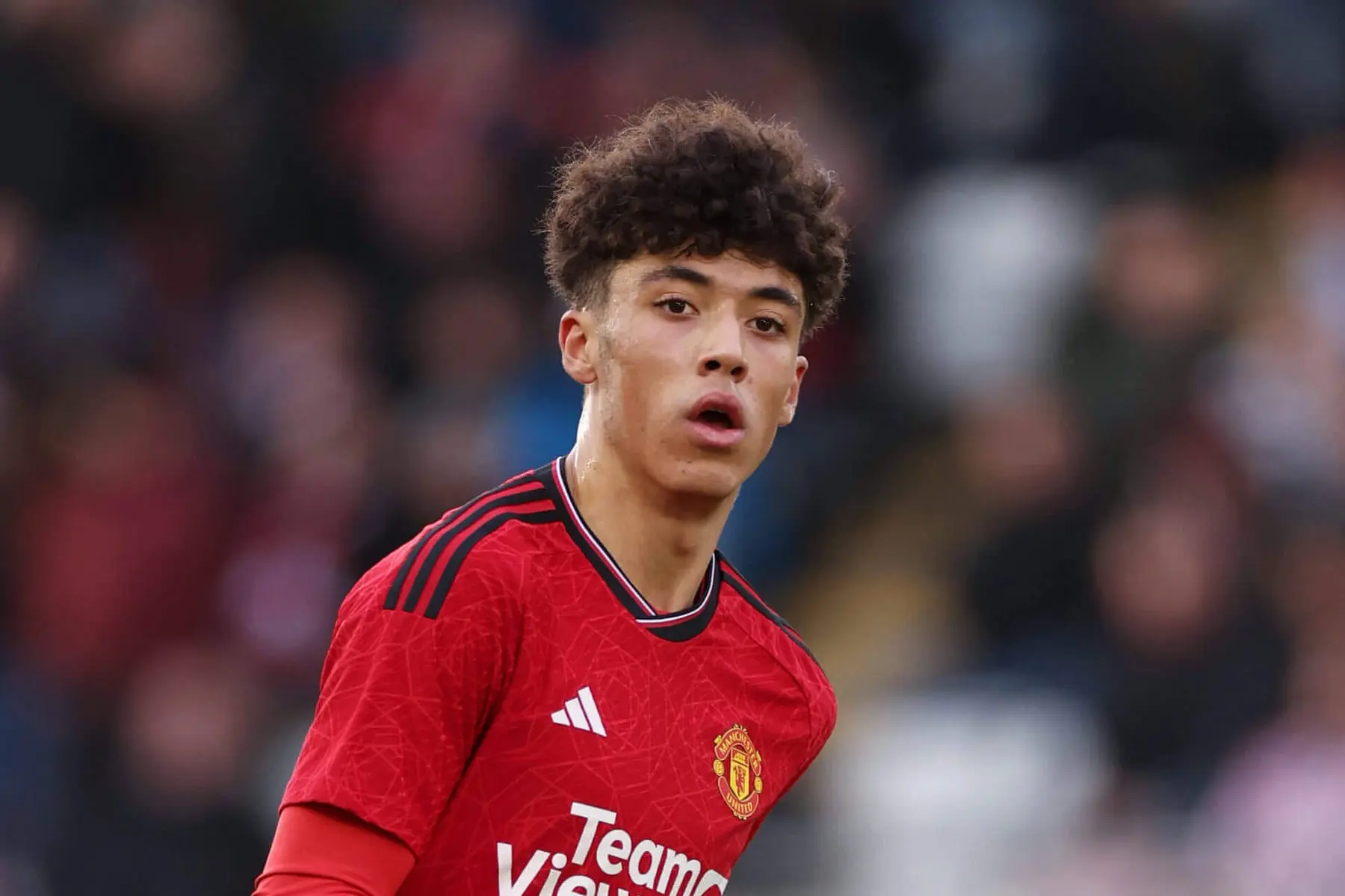Ethan Wheatley in a red Manchester United home kit looking forward during a match