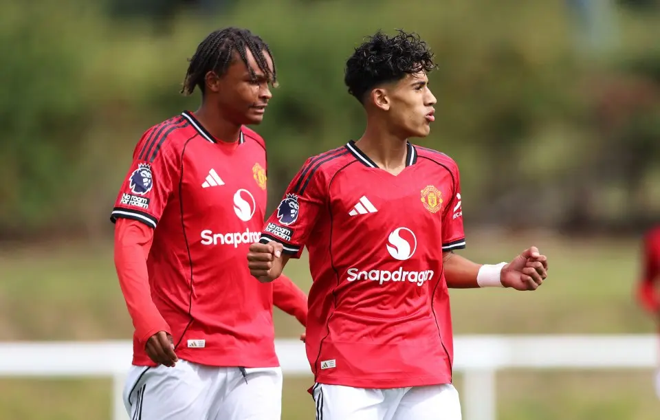 Two young Manchester United players in red home kits during a training session