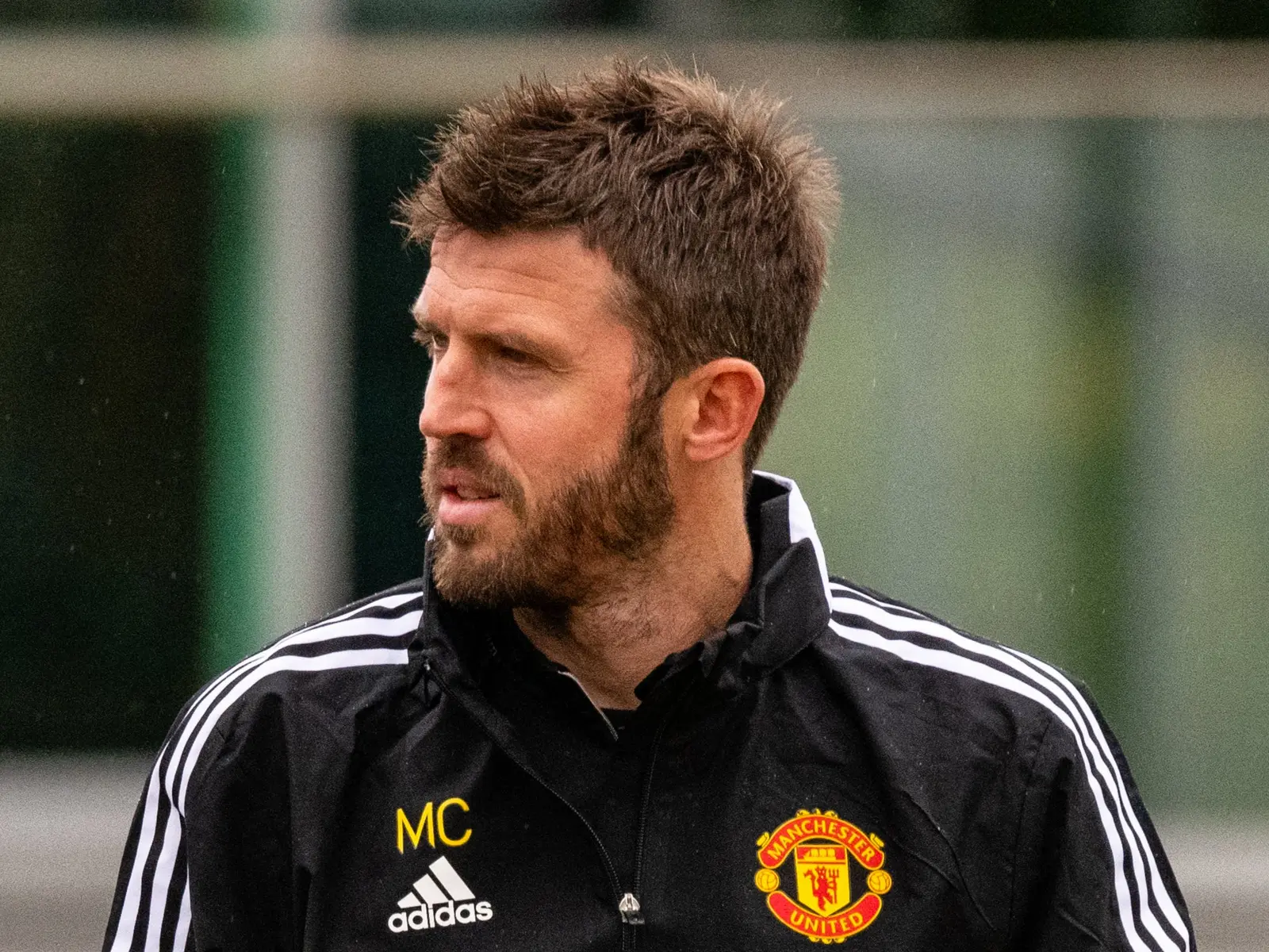 Michael Carrick wearing a black Manchester United training jacket with his initials MC
