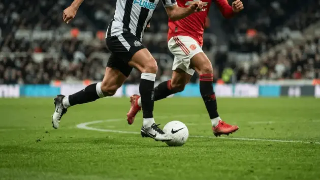 Newcastle and Manchester United kits in motion representing Lewis Hall transfer interest