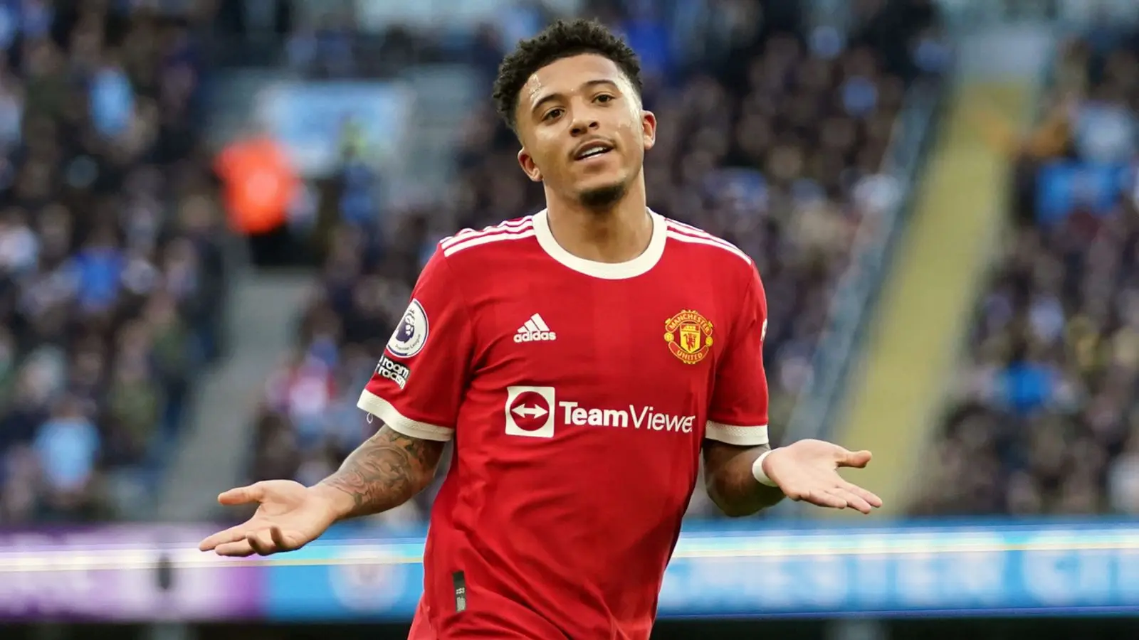 Jadon Sancho wearing a Manchester United home kit with an incredulous expression during a match