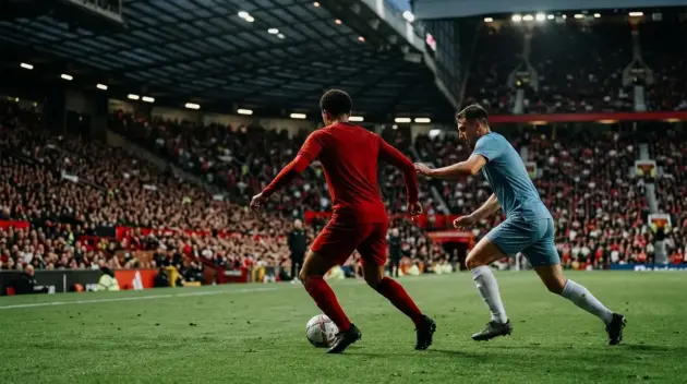 Anonymous red-shirted midfielder controls the ball during a tense derby midfield battle at Old Trafford