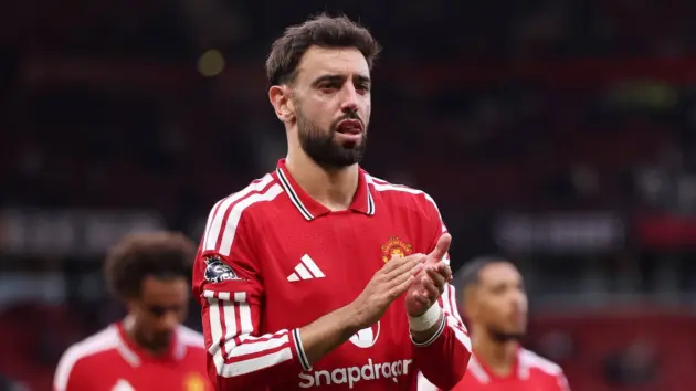A soccer player wearing a red Manchester United jersey with the club crest.
