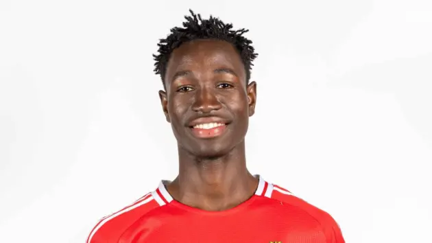 A portrait of Sékou Koné wearing a red Manchester United jersey against a plain white background.