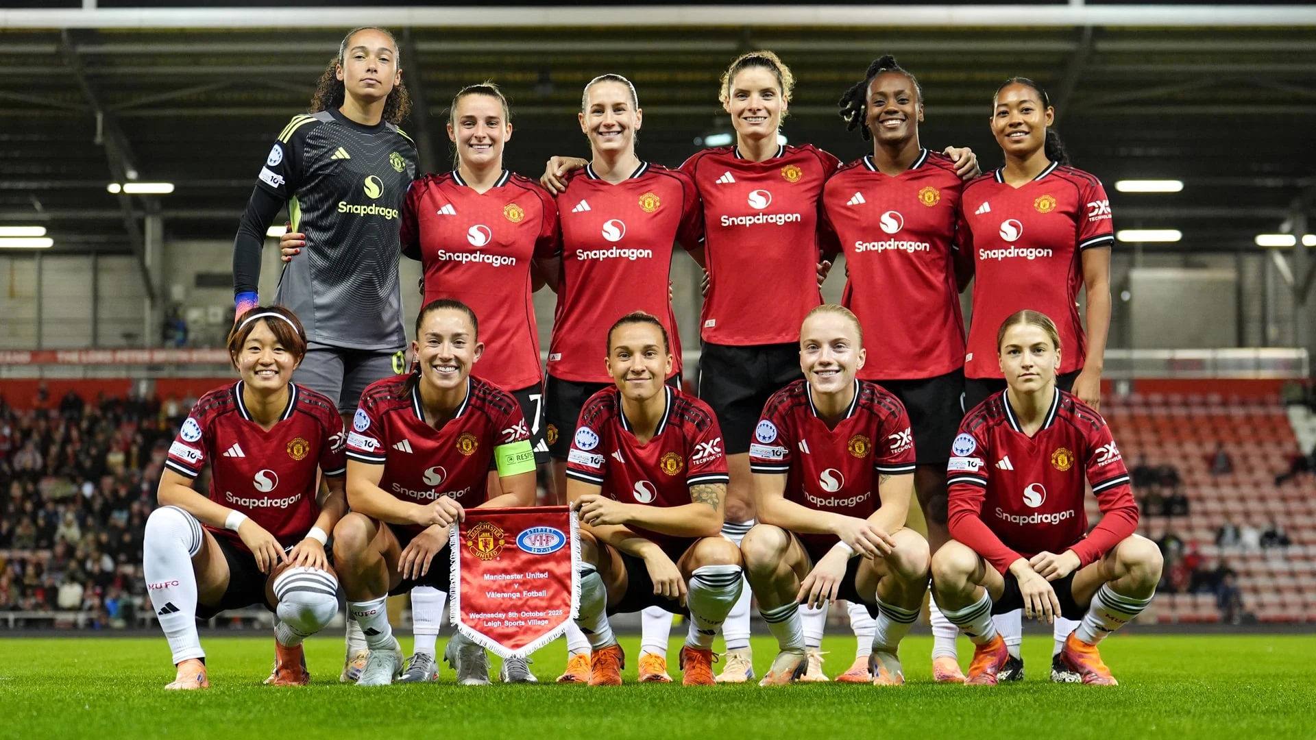 The Manchester United Women's football team posing for a group photo on the pitch.