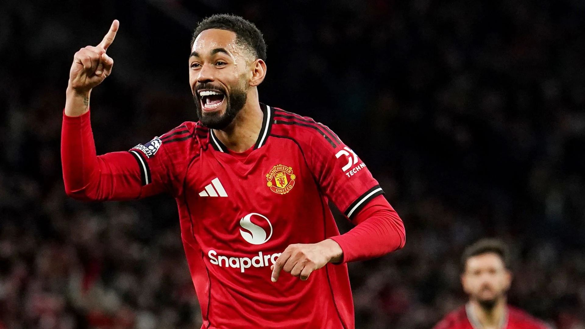 Matheus Cunha celebrating in a Manchester United kit during a match.